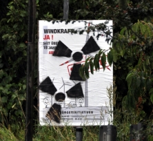 Mit Trefoils besprühtes Anti-Repowering-Plakat am Elbdeich.